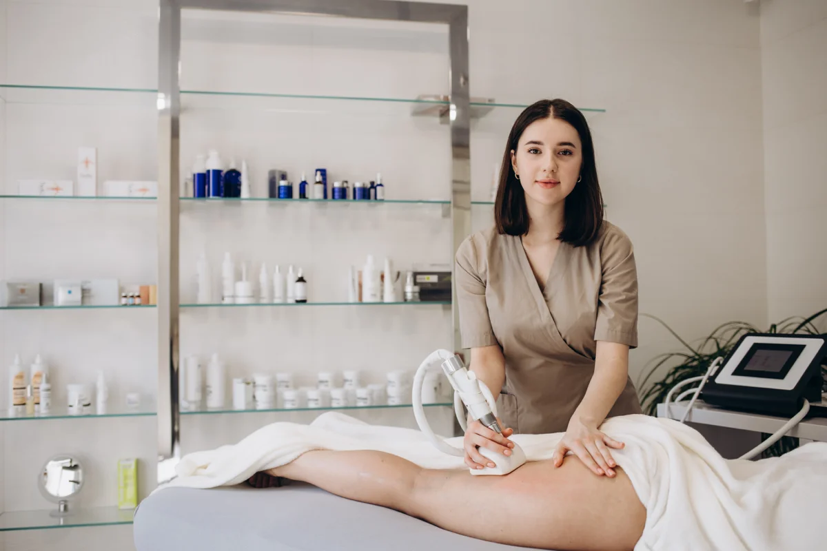 Professionnelle en clinique utilisant un appareil LPG sur une patiente lors d’un traitement esthétique.
